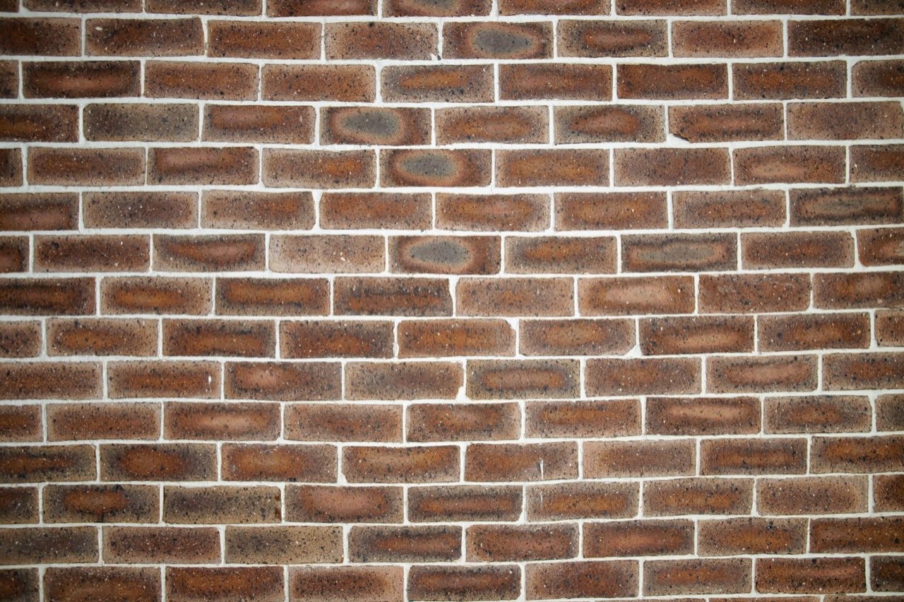 A red brick wall in running bond with pale mortar joints
